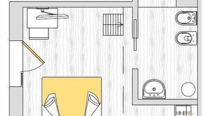 Een plattegrond van een hotelkamer met een badkamer, een kleine kitchenette en een zithoek.