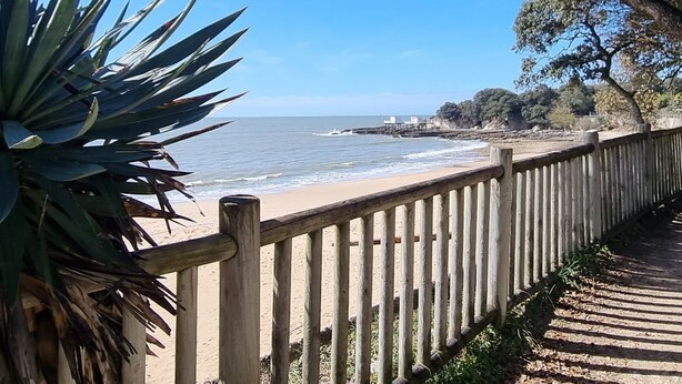 A wooden boardwalk leading to a beach with a clear view of the ocean and distant land. - 
500 m beach studio cabin in residence Cap Atlantic, St Palais/mer swimming pool (Saint-Palais-sur-Mer)