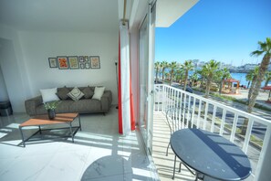 Un balcon avec un canapé, une table et une vue sur le port de plaisance et le panorama de la ville.