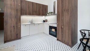 A modern kitchen with wooden cabinets, a white countertop, and a patterned floor.