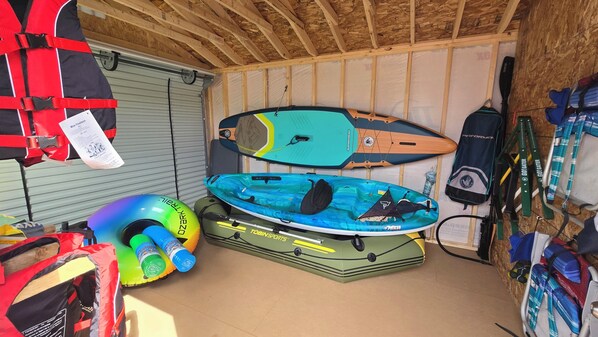 A storage area with kayaks, a life jacket, and a water bottle. - Relaxing spot on the water. Close to many golf courses in the area. (Port Howe)