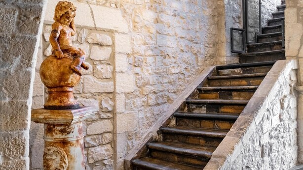 Un escalier en pierre avec une statue sur le côté gauche.