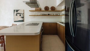 Una cocina moderna con una isla central, electrodomésticos de acero inoxidable y armarios de madera.