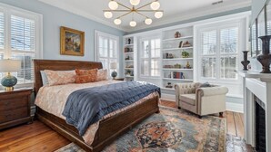 A bedroom with a large bed, a chandelier, a fireplace, and built-in bookshelves. - Palazzo Sul Monte-Due (Wilmington)