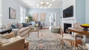 A living room with a sofa, coffee table, and chairs, a fireplace, and artwork on the walls. - Palazzo Sul Monte-Due (Wilmington)