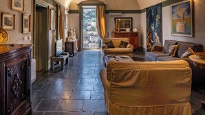 A spacious living room with a high ceiling, a fireplace, and a view of the city through large windows. - Modica Luxury with Terrace (Modica)