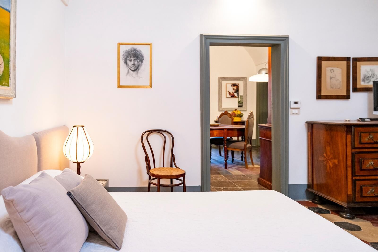 Ein Schlafzimmer mit einem Bett, einem Sessel, einer Lampe und einem Schminktisch.