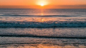 A sunset over the ocean with waves. - The Old Pottery: Spacious 6‑Bed Beach House Sleeping 12 in Rhosneigr | Managed by Anglesey Holiday L (Rhosneigr)
