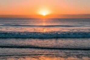 A sunset over the ocean with waves.