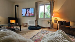 A cozy living room with a fireplace, a television, a sofa, and a lamp.
