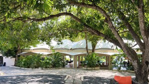 An outdoor seating area with a covered patio, surrounded by lush greenery and trees. - Discover Coronado's Best Area with Pool (Panamá Oeste Province)