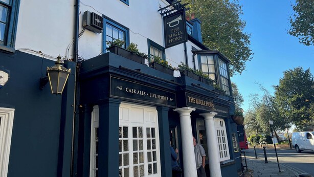 A building with a sign reading "The Bugle Horn" and "Caskales Live Sports". - Stylish apt in a 1938 building w/parking (London)