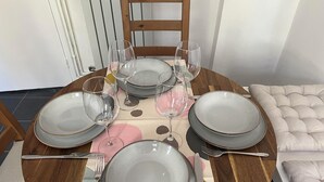 A dining table set with plates, glasses, and cutlery, surrounded by chairs. - Stylish apt in a 1938 building w/parking (London)