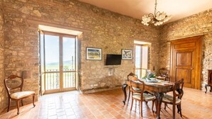 Un coin repas avec un mur en pierre, une table en bois et des chaises.