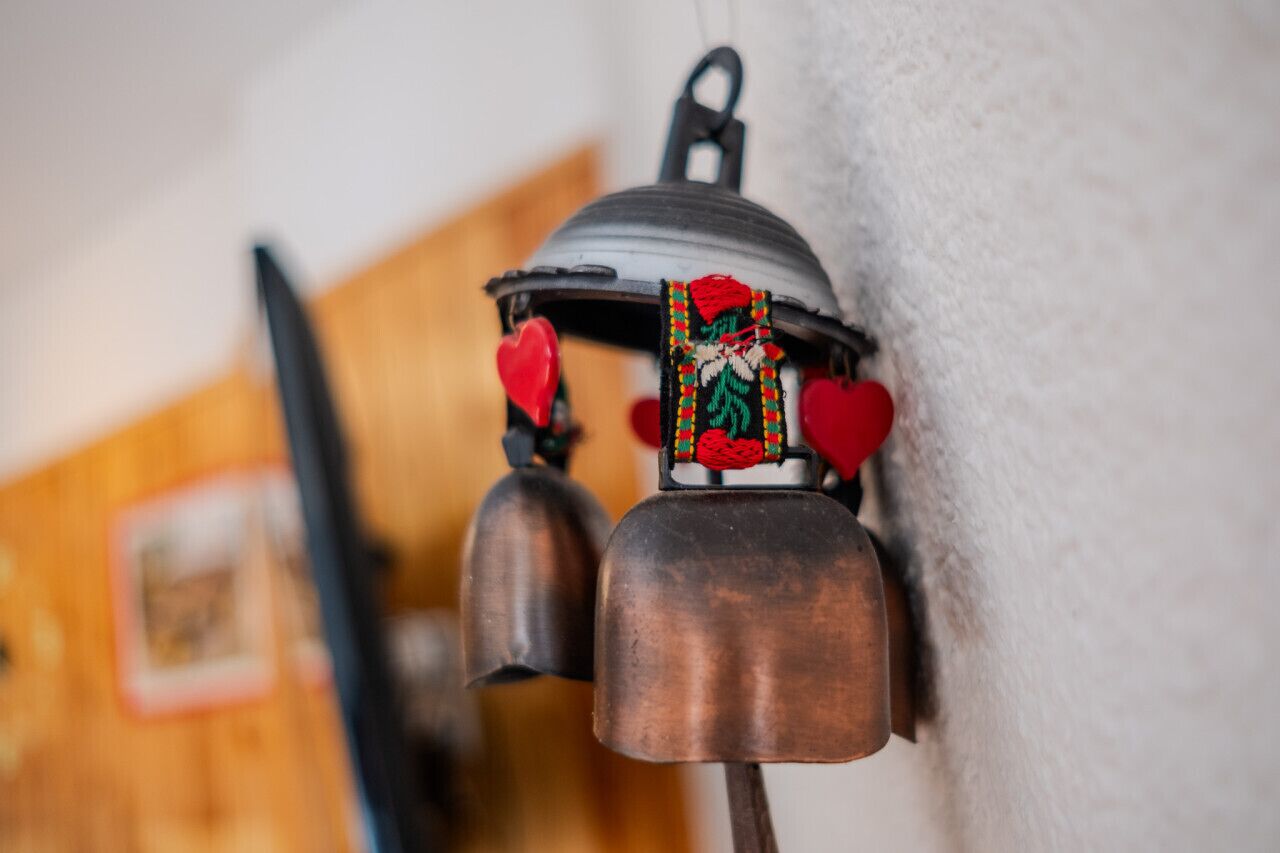 A wall-mounted bell with decorative elements and heart-shaped ornaments.