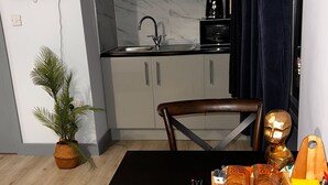 Una cucina moderna con pensili grigi, un piano di lavoro nero e un forno a microonde integrato.