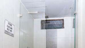 Un bagno con toilette, doccia e porta in vetro.