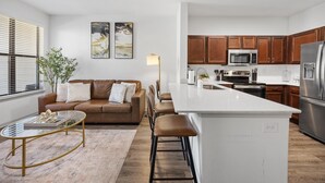 A modern kitchen with wooden cabinets, stainless steel appliances, and a central island.