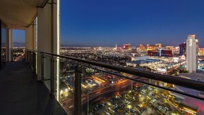 Balkon eines Hochhotels mit Blick auf die Stadt, auf dem sich ein Casino und beleuchtete Gebäude befinden.