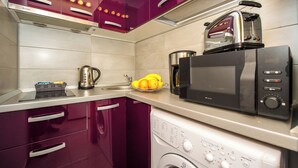 A kitchen with a microwave, toaster, kettle, and washing machine. - Tower Studio – Peaceful Studio with Panoramic View – Next to Cișmigiu Gardens (București)