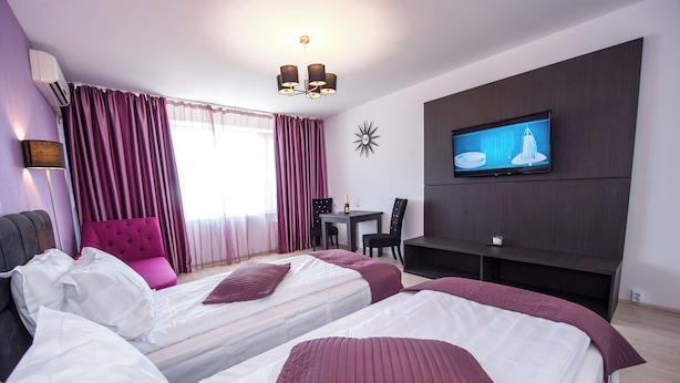 A hotel room with two beds, a TV, a dining table, and a chair. - Tower Studio – Peaceful Studio with Panoramic View – Next to Cișmigiu Gardens (București)