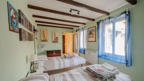 A room with two beds, a radiator, a fan, and artwork on the walls. - Casa Daniele - Savigno (Savigno)