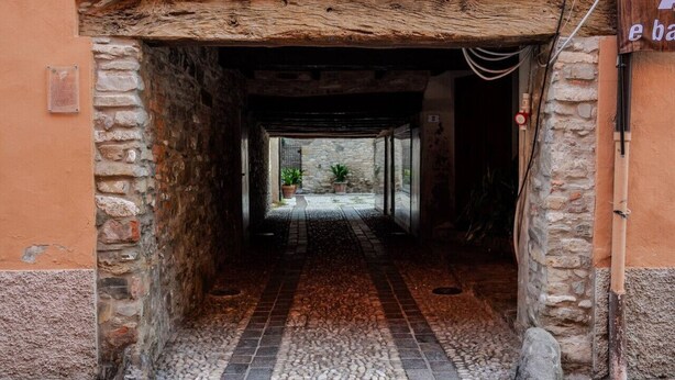 A narrow stone corridor with a tiled floor leading to a courtyard with plants. - Casa Daniele - Savigno (Savigno)