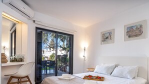 Habitación de hotel con cama, escritorio y silla. Hay dos cuadros en la pared.