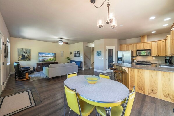 Cozy living space with a round dining table, gray sofa, and mounted TV.