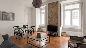 Un salon avec une cheminée, un téléviseur et un coin repas comprenant des chaises et une table.