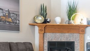 A living room with a fireplace, a sofa, and a coffee table. - Fireplace! Fully Fenced Yard! (Green Bay)