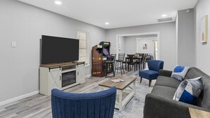 A modern living room with a flat-screen TV, gaming console, and comfortable seating. - Waco Oasis | 5 min to downtown, Magnolia, & Baylor (Waco)