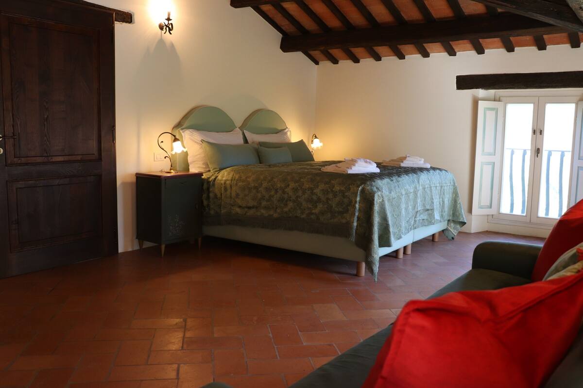 Ein Schlafzimmer mit einem Bett, Nachttischen und einer Holzbalkendecke.