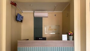 A hotel reception desk with a sign for Doral Inn, a mounted television, and a digital screen displaying a landscape. - DORAL INN HOTEL (Iquitos)