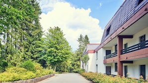 A modern building with a flat roof, a balcony, and a clear sky.