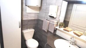 Un baño con inodoro, lavabo y espejo.