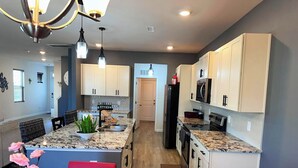 A modern kitchen with granite countertops, white cabinets, and stainless steel appliances. - Simple Elegant Single Fam Home < DT Raleigh NCSU (Raleigh)