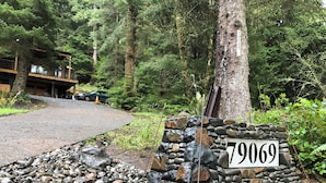 Un letrero de piedra con el número 79069 en una zona boscosa, con un edificio al fondo.