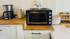 Eine Küche mit Kaffeemaschine, Wasserkocher, Toastern und einer Packung Teebeuteln.