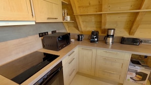 A compact kitchen with a built-in oven, a microwave, a coffee maker, and a toaster.