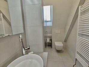 Une salle de bain moderne avec une baignoire, des toilettes et une fenêtre.