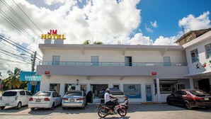 Un hôtel avec une enseigne indiquant « JM HOTEL » et une entrée bien visible.