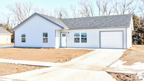 A single-story house with a garage, a front yard, and a driveway.