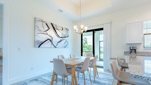 Un comedor moderno con un cuadro abstracto grande, una mesa de madera y sillas.