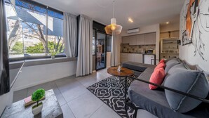 A modern living room with a sofa, a coffee table, and a dining area. - FLIPHAUS Malabia 1900 (Buenos Aires)