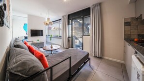 A modern apartment with a sofa, a TV, a dining area, and a balcony. - FLIPHAUS Malabia 1900 (Buenos Aires)