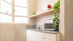 A kitchen with white cabinets, a built-in oven, and a window with a view of the outside. - MOT Maipu 800 (Buenos Aires)
