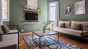 A living room with a sofa, a coffee table, a TV, and a window with curtains. - MOT Maipu 800 (Buenos Aires)
