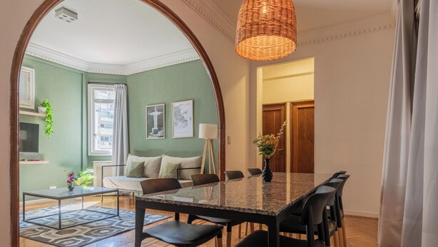 A dining area with a glass-top table, black chairs, and a woven pendant light. - MOT Maipu 800 (Buenos Aires)
