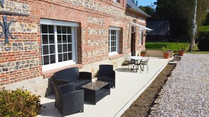 Relax in the serene outdoor seating area, surrounded by lush greenery and comfortable wicker furniture.